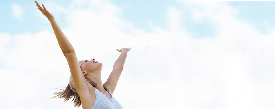 A person standing with arms outstretched against an open sky, from the detox pages